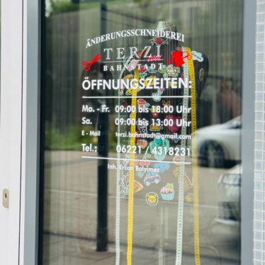Eingangstür der Änderungsschneiderei Terzi mit Öffnungszeiten und Kontaktdaten auf der Glasscheibe